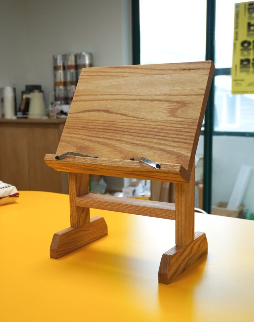 노란 테이블 위에 놓인 원목 책 스탠드