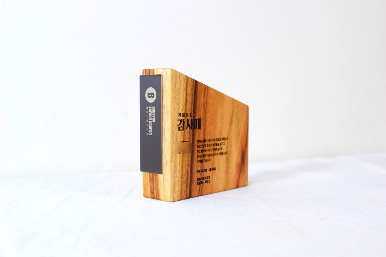 원목 바디와 금속 명판 클로즈업