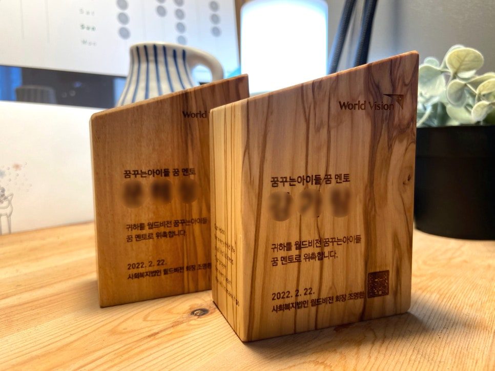 원목 결 위에 새겨진 World Vision 로고