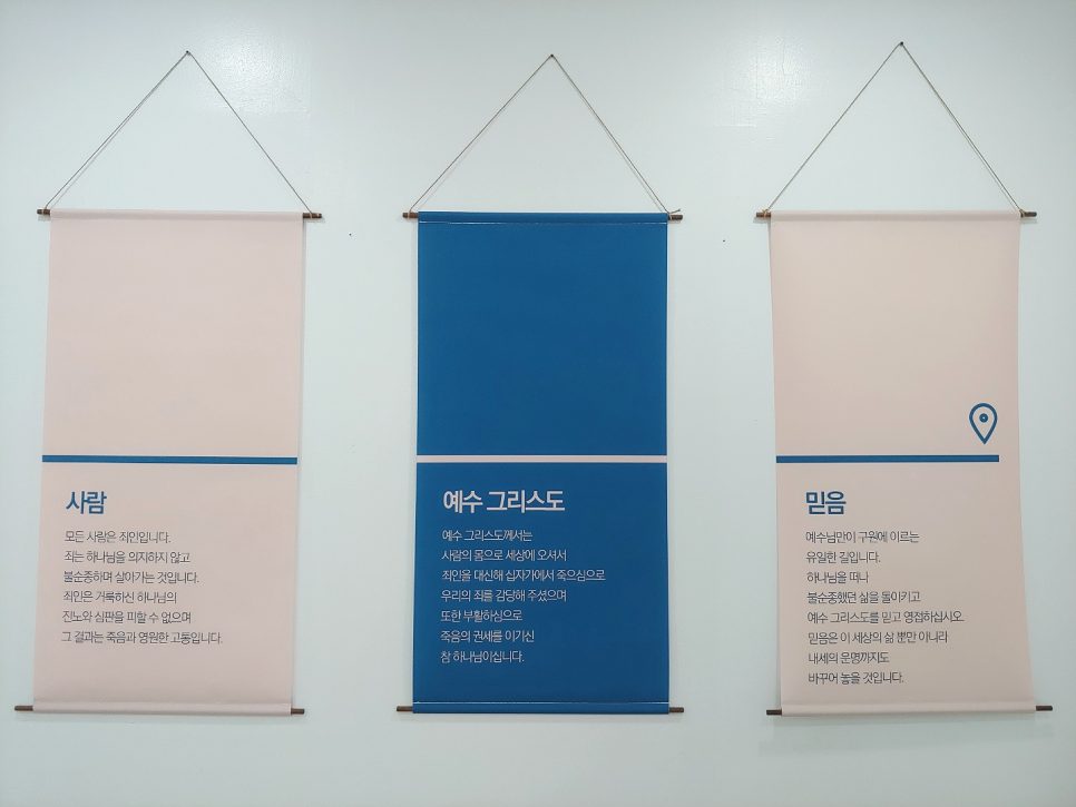 흰 벽에 설치한 4영리 세트 포스터 완성본