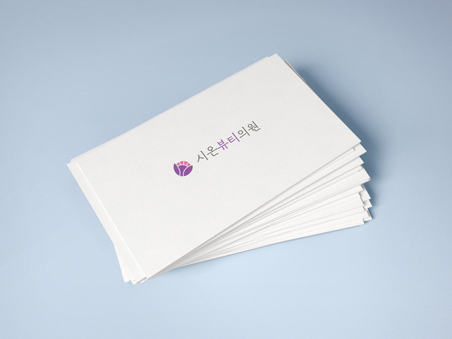 명함 응용 1 (블루 그레이 배경) — 가로 명함 위에 심볼 + 워드마크 한 줄 구성. 심볼이 좌측, 명조 워드마크가 우측에 정렬된 응용 비율.