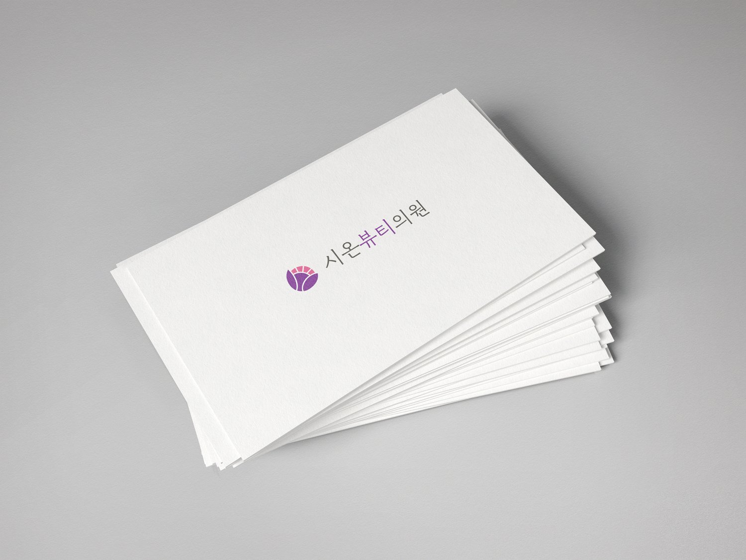 명함 응용 2 (그레이 배경) — 가로 명함 위에 작은 사이즈로 심볼 + 워드마크. 메인 버전을 굿즈 사이즈로 줄여 비율 안정성을 확인하는 컷.