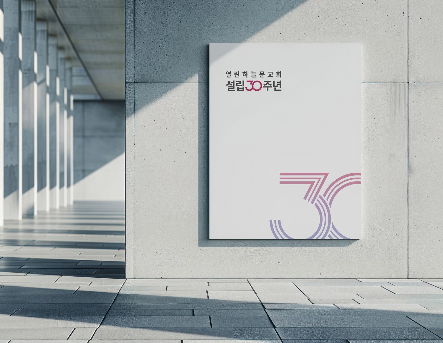 외벽 사이니지 적용 컷 — 콘크리트 외벽에 세워진 큰 사이니지에 엠블럼이 들어갔을 때의 인상을 미리 확인한 컷. 위쪽 한글 워드마크와 아래쪽 큰 엠블럼이 한 면 안에서 어떻게 균형을 잡는지 점검.