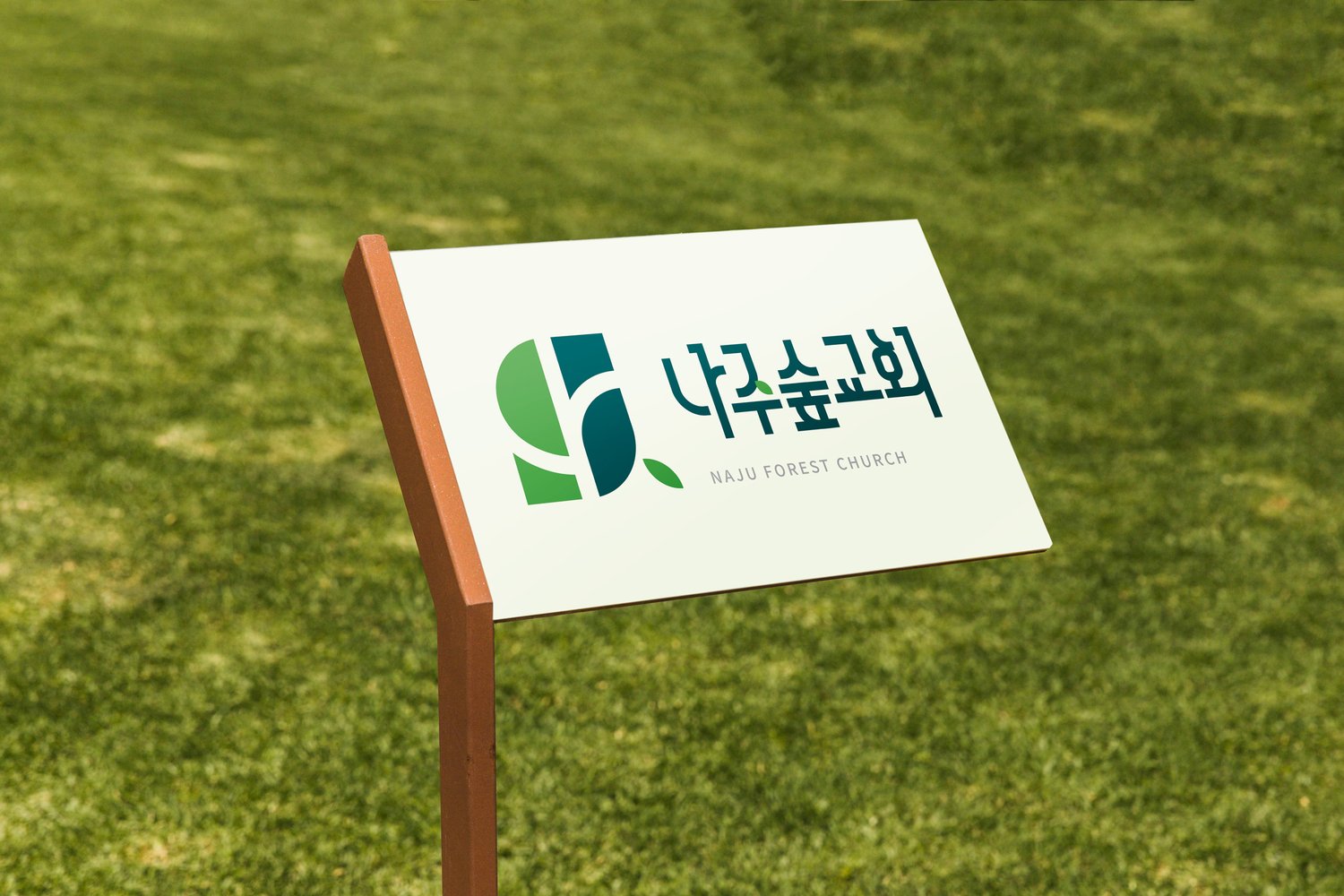 잔디밭 안내판의 가로 조합 — 왼쪽에 심볼, 오른쪽에 한글과 영문이 나란히 앉습니다.