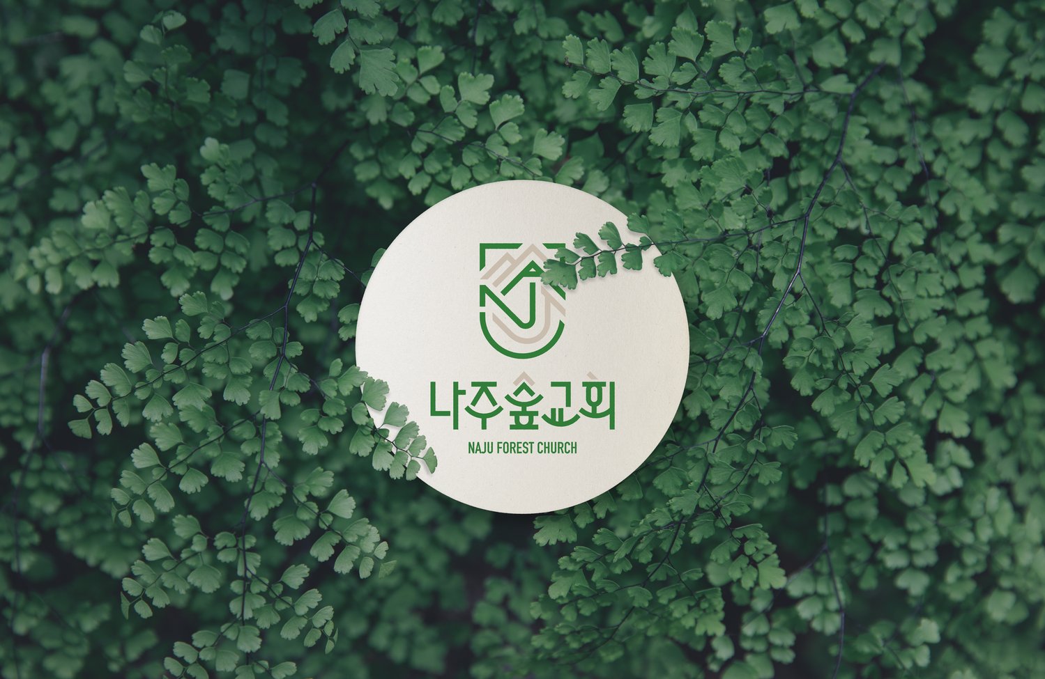 원형 카드 응용 — 잎사귀 사이에서도 로고의 초록이 제 색을 지킵니다.