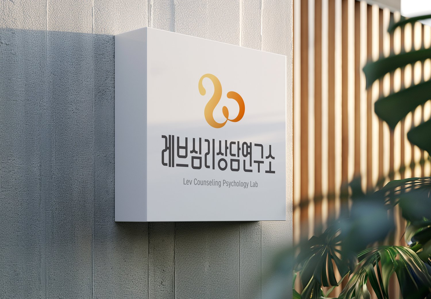 건물 외벽 간판 — 회색 벽 위에서도 곡선의 주황이 먼저 눈에 듭니다.