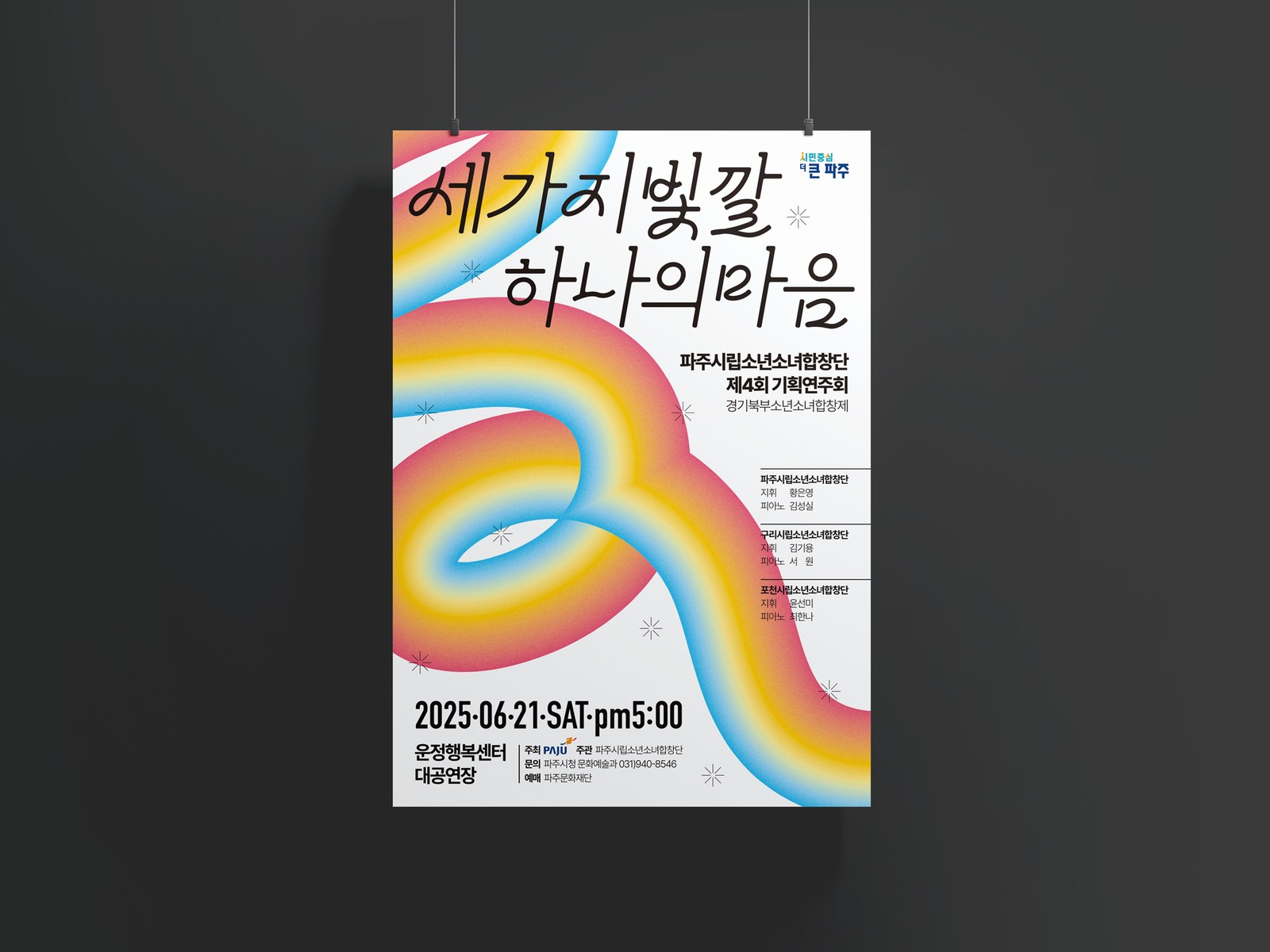 파주시립소년소녀합창단 제4회 기획연주회 포스터 두 번째 시안을 벽에 매단 목업, 흰 바탕에 세 빛깔 리본과 검정 캘리그래피 제목이 보이는 A2 포스터