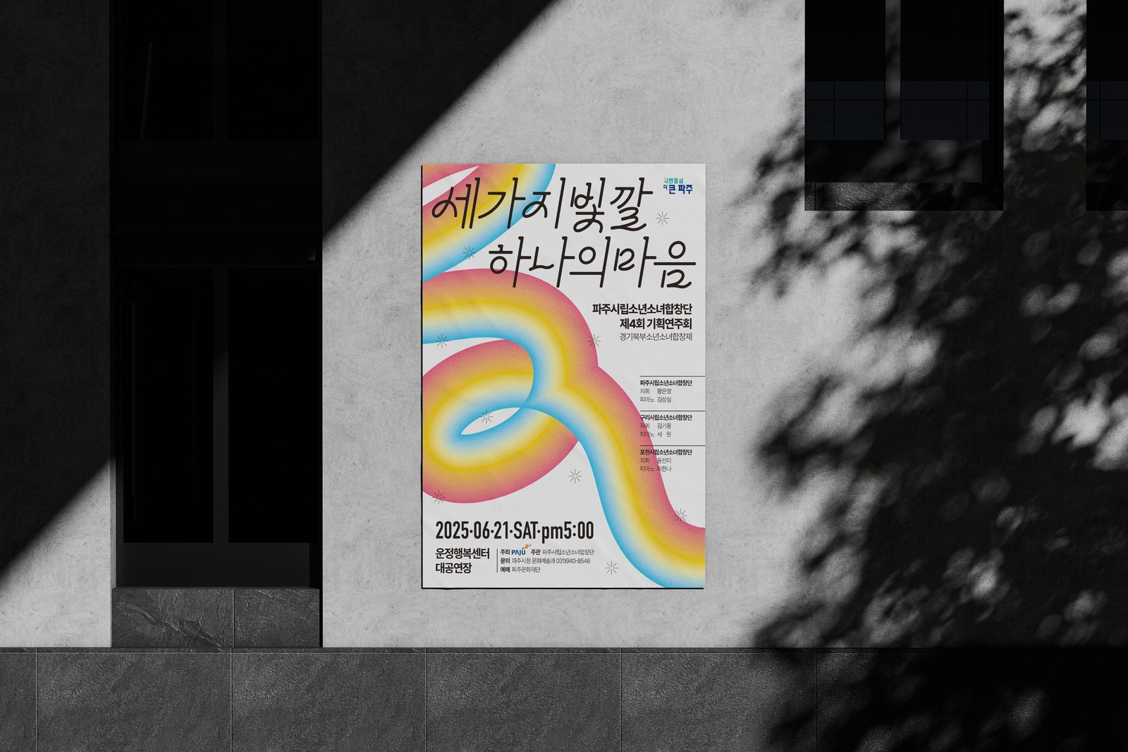 파주시립소년소녀합창단 제4회 기획연주회 포스터 두 번째 시안을 건물 외벽에 붙인 목업, 나뭇잎 그림자가 드리운 흰 벽