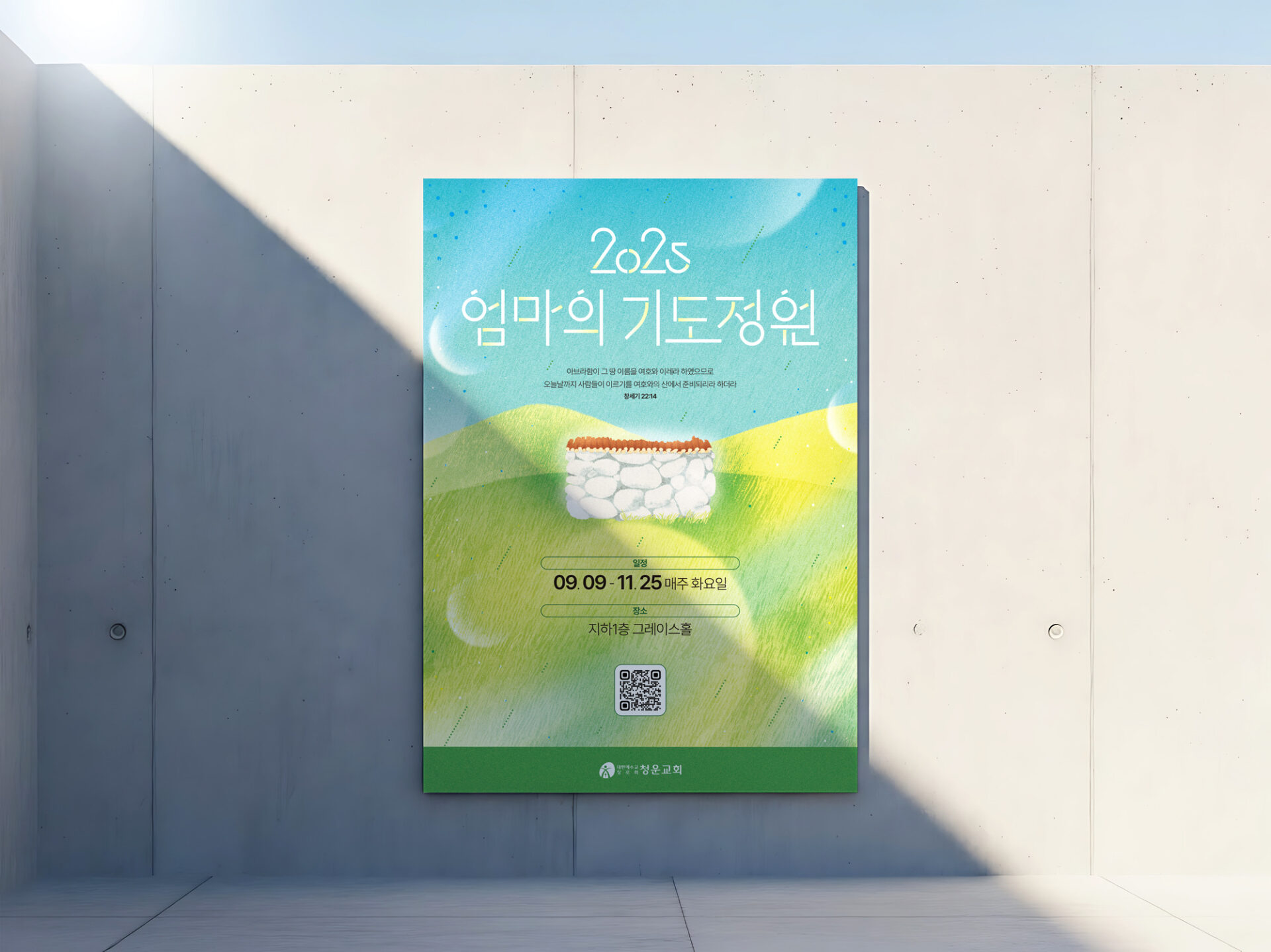 햇빛이 사선으로 들어와 그늘진 면과 밝은 면이 나뉜 콘크리트 벽에 엄마의 기도정원 포스터가 걸려 있습니다.